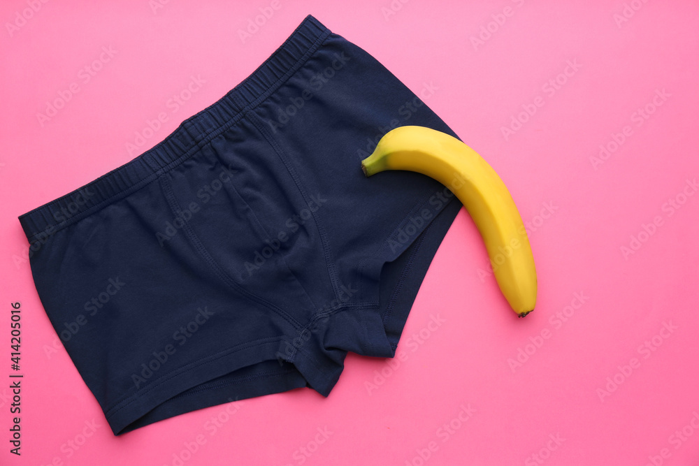 Wall mural Men's underwear and banana on pink background, flat lay. Potency problem concept