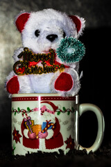Decorated teddy bear in a Christmas cup isolated on black.  Bucharest, Romania, 2020.