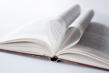 Open book with heart shape page. Love reading books concept. Romantic written love story.