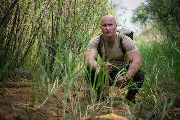 Naklejka na ściany i meble An adventurer with a machete is sitting in the jungle.