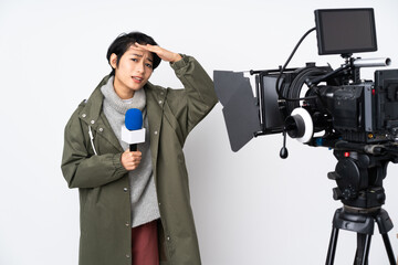 Reporter Vietnamese woman holding a microphone and reporting news looking far away with hand to look something
