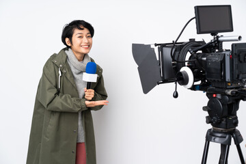 Reporter Vietnamese woman holding a microphone and reporting news presenting an idea while looking...
