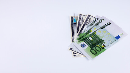 dollars and euros with vaccine and syringe on white background