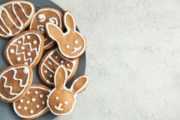 Easter cookies on a grey plate on a stone background. Easter bunnies. Copy space and top view.