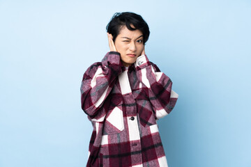 Young Vietnamese woman with short hair over isolated background frustrated and covering ears