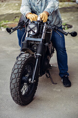 Naklejka premium The front part of the motorcycle wheel with the rider sitting with the lamp with tape cross over optic. Motorcycles to order. Casual concept