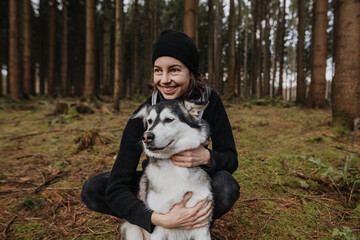 Junge Frau verbringt Zeit mit ihrem Hund in der Natur 
