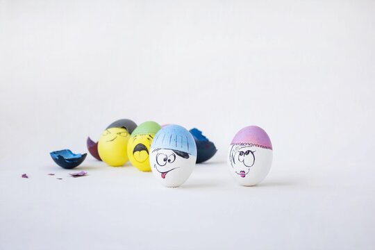 Lots of eggs on a white isolated background. Eggs in hats with cheerful faces. Celebration and joy. Happy easter. Hand-painted eggs. Easter garland.