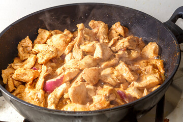 Chicken fillet in soy sauce with lemon juice in a frying pan.