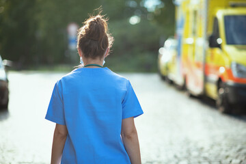modern medical doctor woman outside near ambulance walking