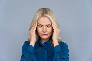 Stressed frustrated middle aged lady suffering from headache massaging temples, close up view....
