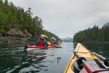 Canada, British Columbia. Sea kayakers paddle through Blackney Passage on an adventure near Johnstone Strait.