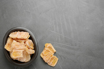 Delicious dried jackfruit slices on grey table, flat lay. Space for text