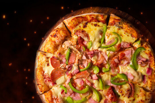 Pizza de pepperoni con piment&oacute;n, fondo negro.