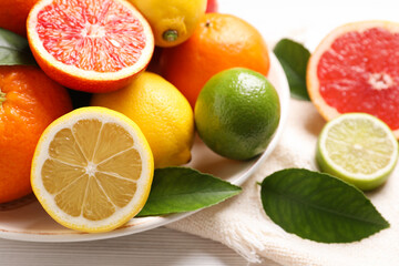 Fototapeta na wymiar Different citrus fruits on white wooden table, closeup
