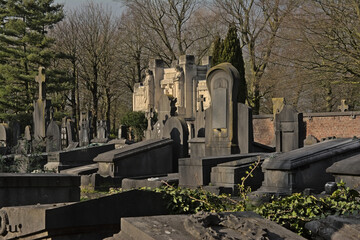 Old grave tombs in between trees in Westerbegraafplaats cemetery, Ghent, Flanders, Belgium 