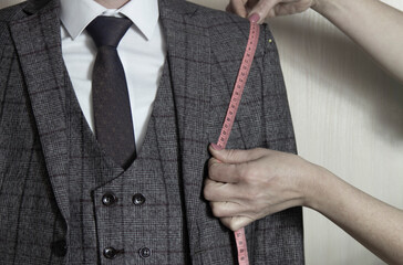 Mid section portrait of tailor fitting bespoke suit to model
