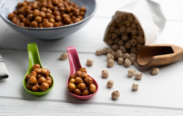 Vegan grilled chickpeas. Homemade vegan chickpeas, Crispy roasted organic chickpeas . Served as a snack in a bowl, on a white background.