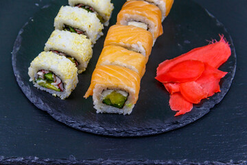 Set of sushi rolls on a black stone slate