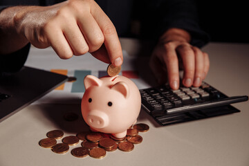 Man putting coin in pink piggy bank. Saving money concept.
