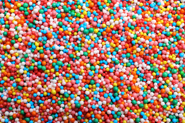 Fototapeta na wymiar Bright colorful sprinkles as background, top view. Confectionery decor