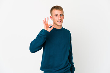 Young caucasian handsome man cheerful and confident showing ok gesture.