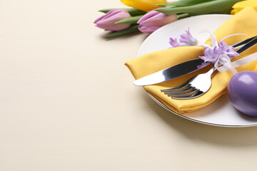 Festive Easter table setting with egg on beige background. Space for text