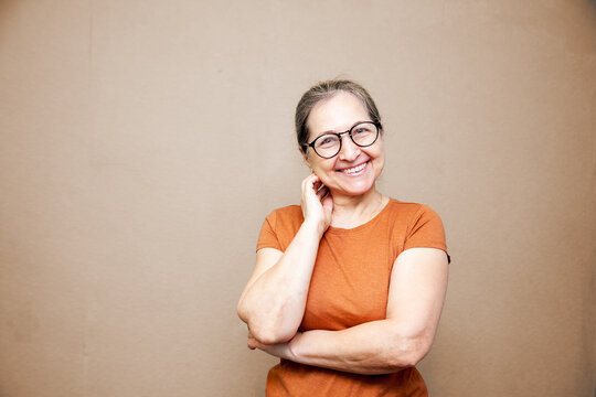 Portrait of  elderly woman in  brown T-shirt and glasses