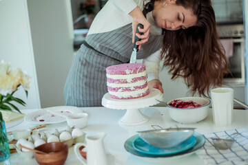 Young beautiful woman bakes a cake. Sweets. Confectionery.