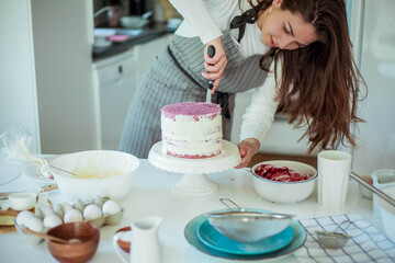 Young beautiful woman bakes a cake. Sweets. Confectionery.