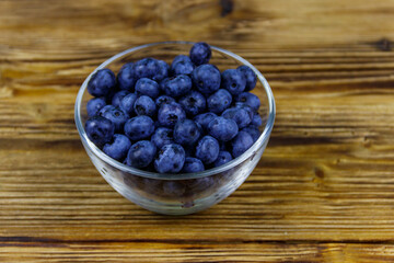 Fresh blueberry in glass bowl on a wooden table