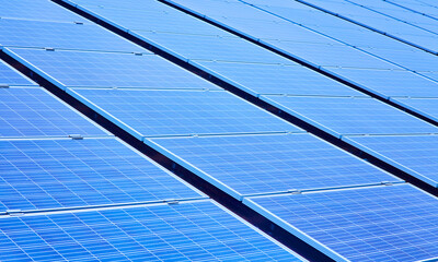 large solar energy system, ground mounted solar panel against blue sky.