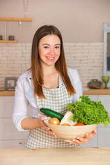 young woman housewife prepares in her kitchen.