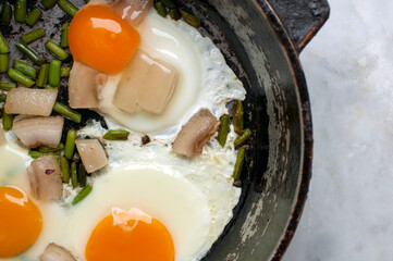 scrambled eggs with lard on a frying pan