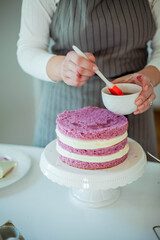 Young beautiful woman bakes a cake. Sweets. Confectionery.