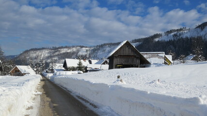 Traditional village with hayrack in Bohinj covered with a snow