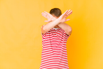 Young caucasian handsome man keeping two arms crossed, denial concept.