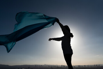Silhouette of a woman with blue shawl 