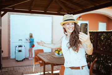 happy elegant mother and child in hats answering incoming call