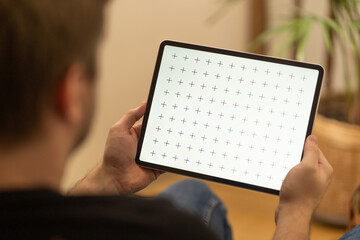 Young man watching movie on ipad. Horizontal video content mock-up.