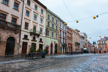 Fototapeta na wymiar LVIV, UKRAINE: Rainy weather at town Market Square with lamposts and cobbled streets on. Lviv's Old Town is a part of UNESCO World Heritage List