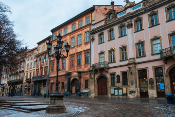 Obraz premium LVIV, UKRAINE: Rainy weather at town Market Square with lamposts and cobbled streets on. Lviv's Old Town is a part of UNESCO World Heritage List