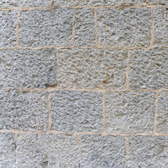 old stone wall made of sandstone blocks of different sizes as background