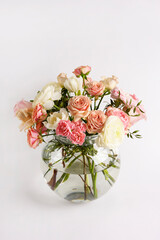 Beautiful flowers in vase on a table with white background. Women's, mother's day, love concept. Spring, summer season.