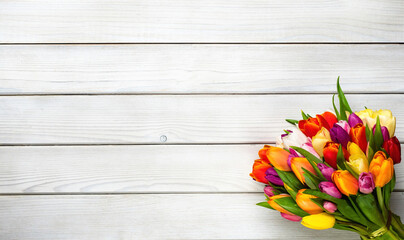 Colorful bouquet of tulips on white wooden background. Spring flowers. Greeting card with copy...