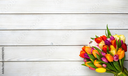 Colorful bouquet of tulips on white wooden background. Spring flowers. Greeting card with copy space for Valentine's Day, Woman's Day and Mother's Day.