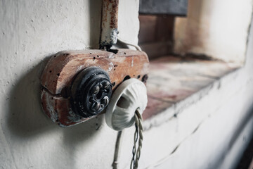 Very old, broken and damaged light plugs, with a decayed wooden bracket, inside an old and...