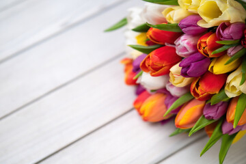 Colorful bouquet of tulips on white wooden background. Spring flowers. Greeting card with copy space for Valentine's Day, Woman's Day and Mother's Day.