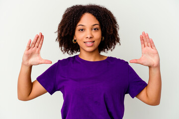 Young african american mixed race woman isolated holding something little with forefingers, smiling and confident.