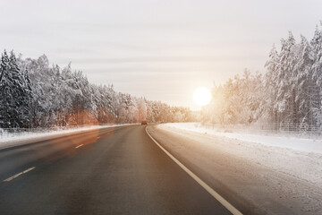 Fototapeta na wymiar Winter highway. The road leading through the winter landscape. Sunlight. Horizontal photo.